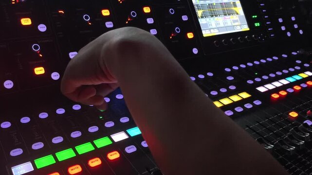 Close up of a music producer adjusting professional audio mixer controls in a recording studio, showcasing sound engineering, music production, creative workflow, frequency balancing, technology.