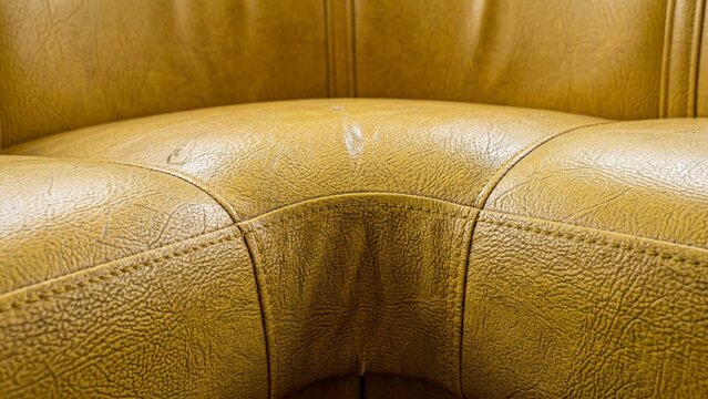 Close Texture of Yellow Leather Sofa with Seams and Wear
