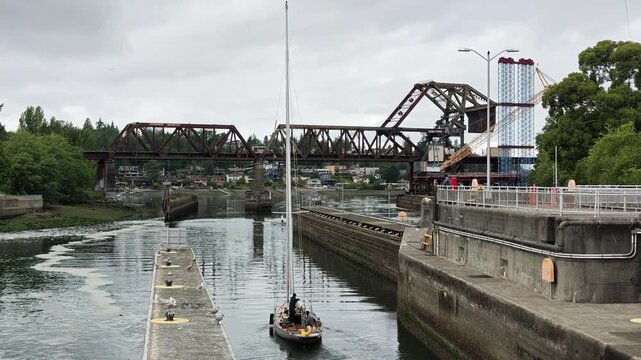 Sailboat in canal near raised steel bridge