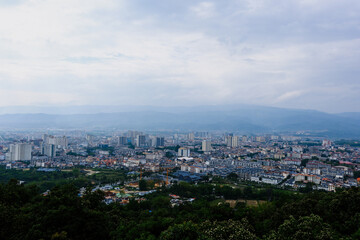 Fototapeta premium City skyline from hillside under cloudy sky