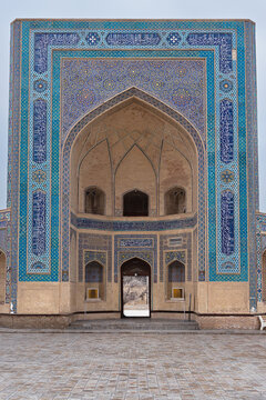 Kalyan Madrasa facade with ornate tilework on Poi Kalyan Square in Bukhara Uzbekistan. Monumental iwan portal decorated with blue and turquoise mosaics and Arabic calligraphy, ideal for travel.
