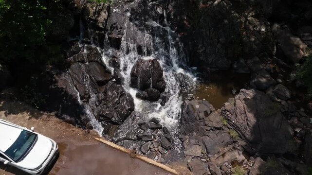 Surlabbi Waterfalls with rocks, bridges and parked car at Madikeri, Coorg, Surlabi, Kodagu, karnataka, india. day time, zib shot, drone shot, 4k.