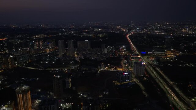 Aerial View of Hyderabad cityscape with illuminated ORR, vehicles and Skyscrapers at Financial District, nanakramguda, Kokapet, Telangana, india. day time, trucking shot, drone shot, 4k.