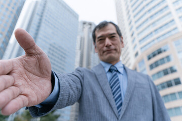 Fototapeta premium 手を差し出す日本人ビジネスマンの信頼イメージ