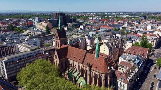 Panoramic drone fly around the neo-Romanesque Saint-Pierre-le-Jeune Protestant Church with exterior facade details and elements, Strasbourg, France