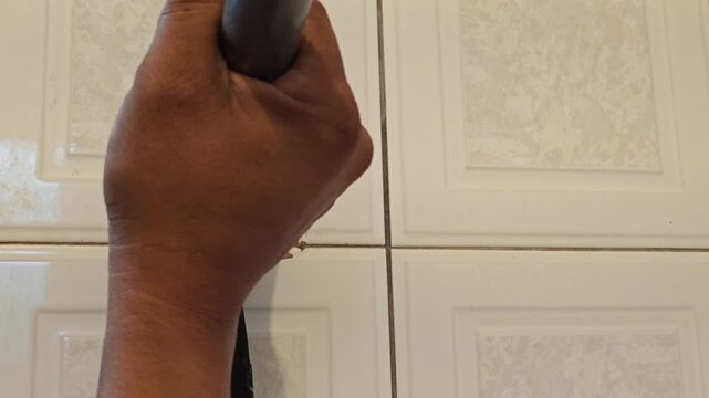 Close up hand removing old nail from wall using hammer claw