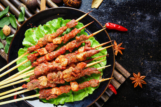 Spicy Grilled Meat Skewers with Chili Seasoning on Lettuce Leaves - Asian Street Food Barbecue