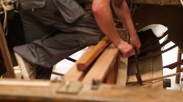 Fitting oak rib into hull of clinker wood boat