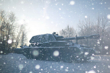 Naklejka premium Military tank in a row. Battle tank in the snow on the roadside of highway. War in Ukraine in winter.