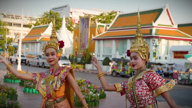 Two Thai Dancers in Traditional Chut Thai Costumes Perform Outdoors