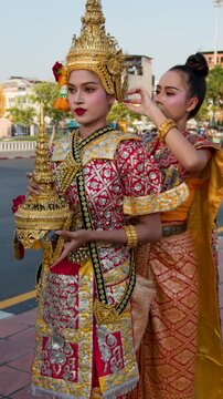 Traditional Thai Khon Dancers Adjusting Golden Headdresses in Bangkok Cityscape