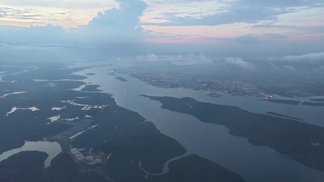 Aerial view of winding river delta and coastal landscape under cloudy dusk sky