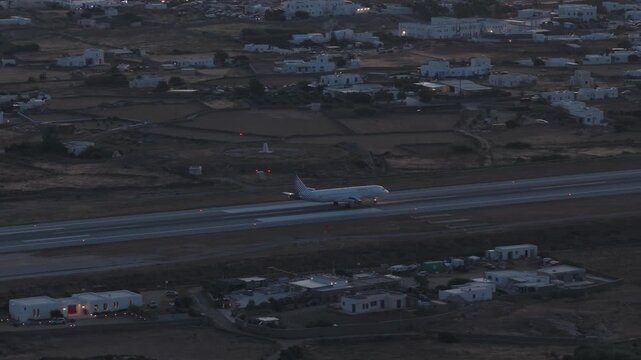 Commercial airplane landing at Mykonos Island National Airport in Greece at dusk, passenger transport and aviation technology on a mediterranean island holiday