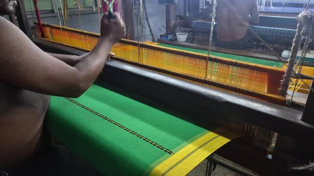 4k 120 fps slow motion video of a  handloom weaver in India working in his loom.	