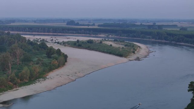 Oo River flows through broad exposed sandbars near Cremona, Lombardy, Italy, during an intense summer drought and heatwave, low water levels, active sediment deposits and valley floodplains, aerial