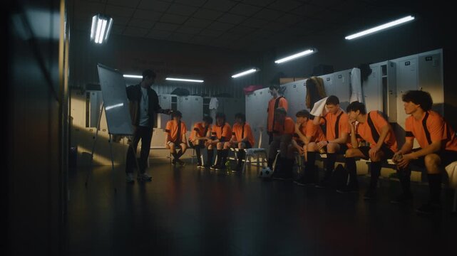 Male Coach Uses Flipchart With Drawn Schemes to Explain Game Tactics and Strategy to Focused Teenage Football Team in Moody Locker Room Before an Important Match. Concept of Authority and Respect.