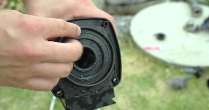 Close-up of a person installing the O-ring seal onto a cleaned pump housing during reassembly. Maintenance concept of pump repair, sealing, servicing, and mechanical assembly.