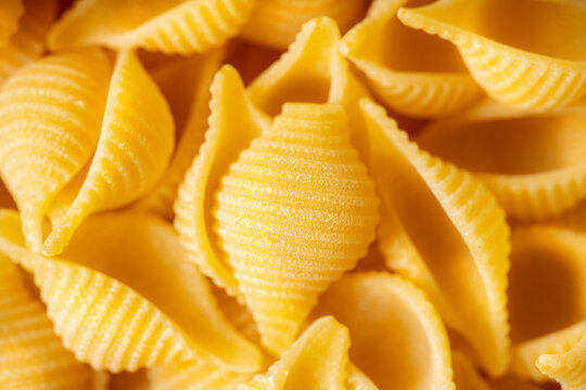 Dry pasta shells as textured background. Shot from above. Background and textures.