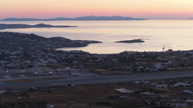 Mykonos International Airport showcasing airplanes on runway during scenic sunset over Aegean Sea in Greece, spectacular landscape for summer holiday and travel