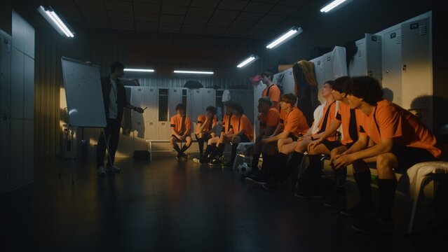 Professional Football Coach Leads Tactical Session in Locker Room, Using Flipchart to Demonstrate Game Plan to Teenage Players. Importance of Theoretical Preparation and Leadership in Youth Sports.