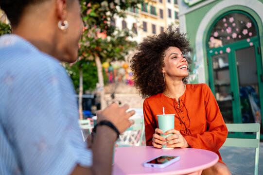 Young couple on a romantic date at a colorful outdoor cafe, sharing drinks and conversation