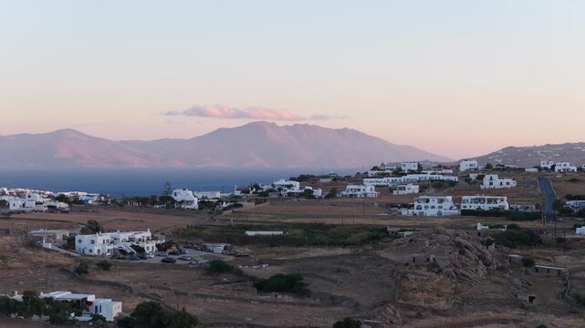 Cycladic architecture on Mykonos island, Greece during romantic sunset over Aegean Sea with Tinos and Delos islands in background, popular summer holiday destination