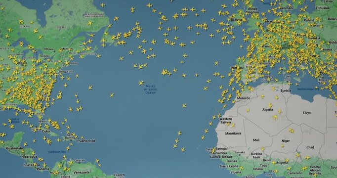 Time lapse of busy air traffic over map on digital screen.
