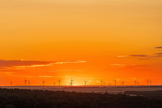 Wind turbines on field at sunset