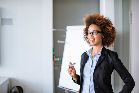 Smiling businesswoman leading a presentation at flip chart in office