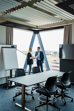 Male and female entrepreneurs discussing in board room