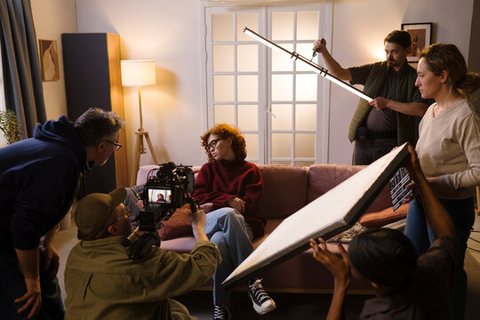 Film crew shoots a scene with an actress indoors