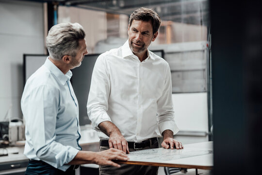 Business people discussing over plan while working at industry