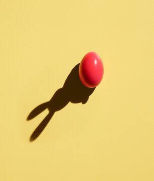 Pink Easter egg with shadow of bunny ears