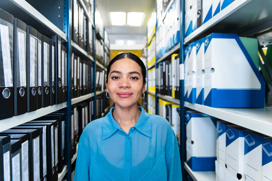 A confident businesswoman organizes files in an office archive