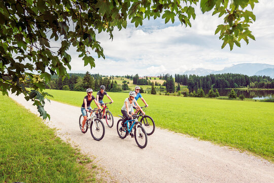 Germany, Bavaria, Pfronten, family riding mountain bikes at ladeside