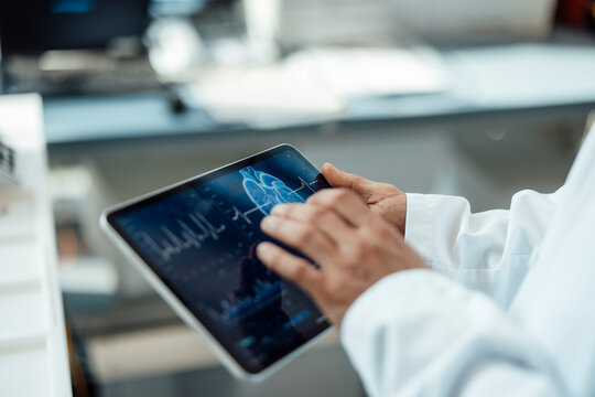 Researcher analyzing medical data on a tablet in a laboratory