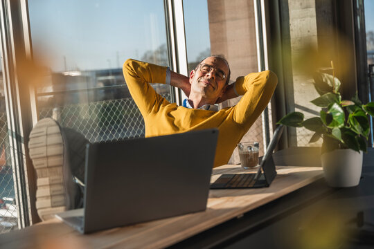 Businessman with hands behind head relaxing in office