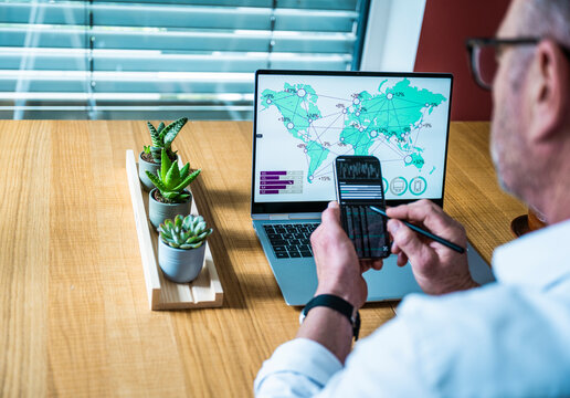 Businessman analyzes data on notebook and mobile in the office