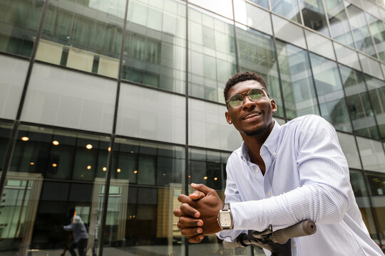 Thoughtful man with hands clasped in front of building