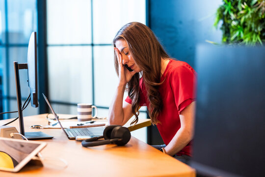 Frustrated businesswoman sitting at desk in office
