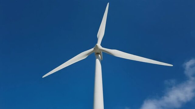 Wind turbine against blue sky background.