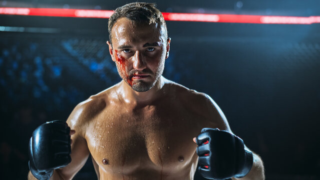MMA Fighters Face Off in a Brutal Fight Inside the Cage as a Bloodied Athlete Keeps His Guard Up, Raw Contact Sport Action Showing Toughness, Pain, and Will, Fight for the Champion Title Belt.