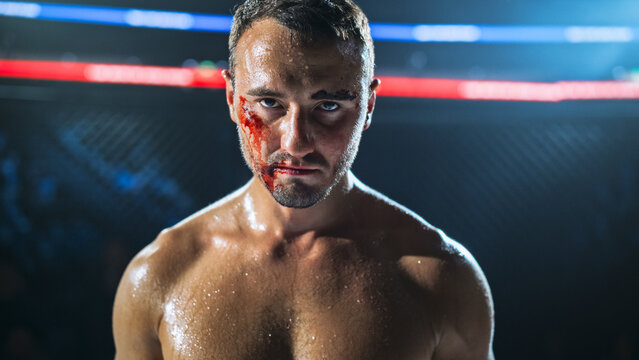 MMA Fighters in a Hard Fight Inside the Cage, With One Fighter Staring at the Camera, Bloodied and Tired. Raw Contact Sport Moment Showing Pain, Focus, and Grit, Fight for the Champion Title Belt.
