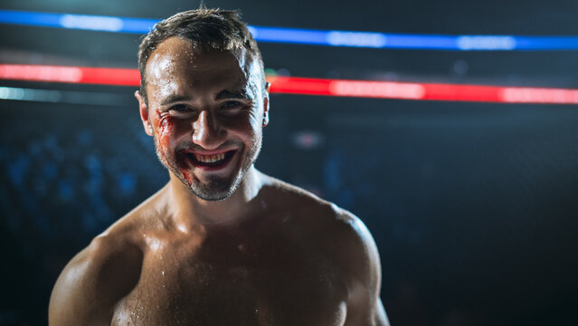 MMA Fighters Finish a Hard Fight Inside the Cage as a Bloodied Fighter Smiles After the Win.  Competitive Fight for the Champion Title Belt, With Sweat, Cuts, and Tough Endurance.