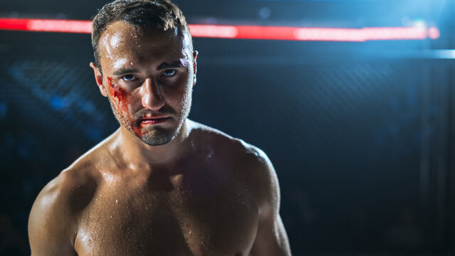 MMA Fighters Trade Blows in a Fierce Fight Inside the Cage. One Bloodied Fighter Looks Straight Ahead, Competitive Fight for the Champion Title Belt in Raw Contact Sport Action.