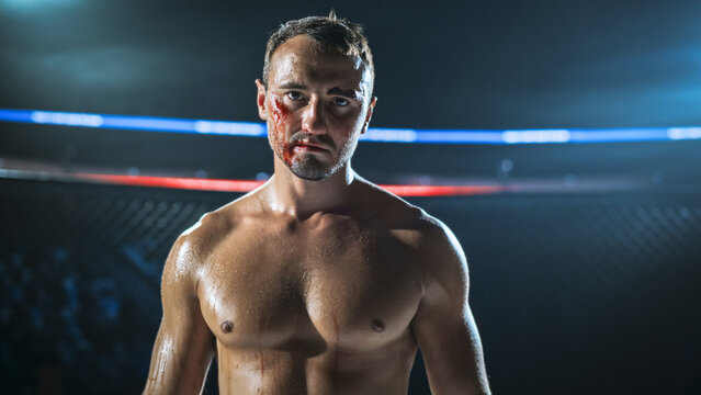 MMA Fighters Face Off in a Cage Fight After Heavy Strikes. a Bloodied Fighter Stares Into the Camera With Calm Focus, Sweat and Cuts Showing Contact, Grit, PressureFight for the Champion Title Belt