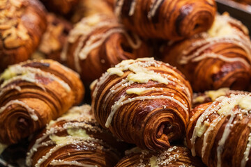 Fototapeta premium Cream Drizzled Croissants In Display Close Up