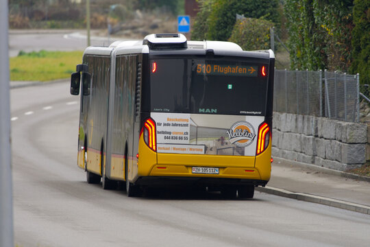 Swiss Post bus line 510 destination Zurich Airport passing at Swiss village of Niederhasli on a gray autumn day. Photo taken December 14th, 2025, Zurich Niederhasli, Switzerland.