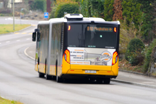 Swiss Post bus line 510 destination Zurich Airport passing at Swiss village of Niederhasli on a gray autumn day. Photo taken December 14th, 2025, Zurich Niederhasli, Switzerland.