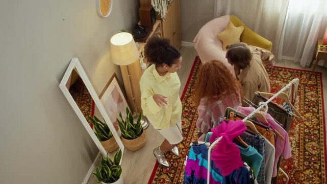 Multiethnic girls trying on vintage clothes, dancing and laughing in front of mirror. Clip is ideal for fashion retail marketing, youth lifestyle campaigns and apparel brand advertisements